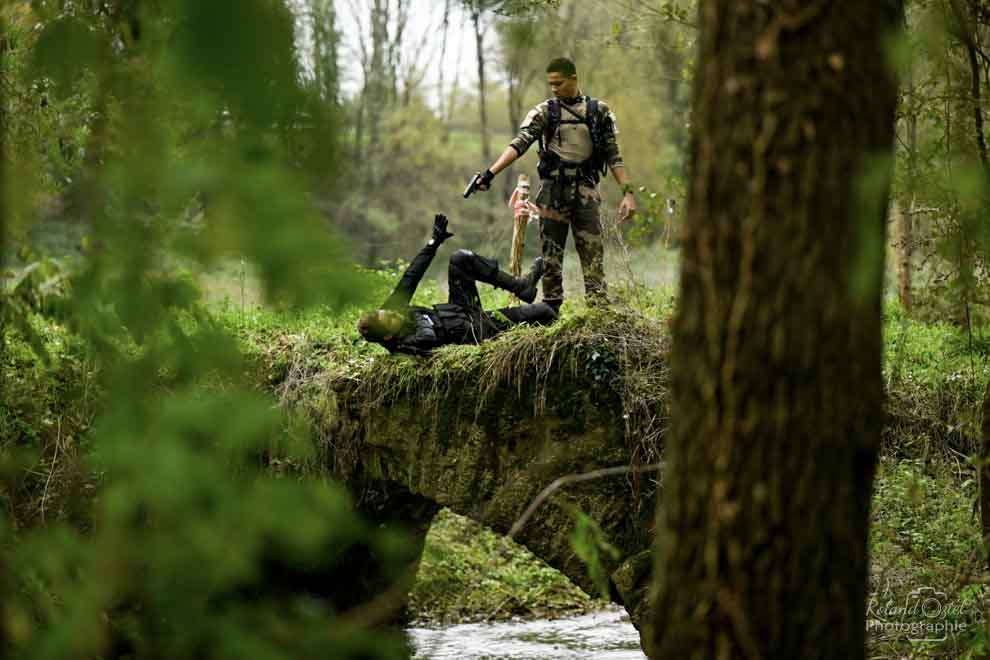 Photo dans un bois avec un militaire menaçant un autre