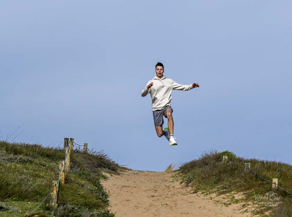 Shooting photo jeune homme sautant au dessus des dunes