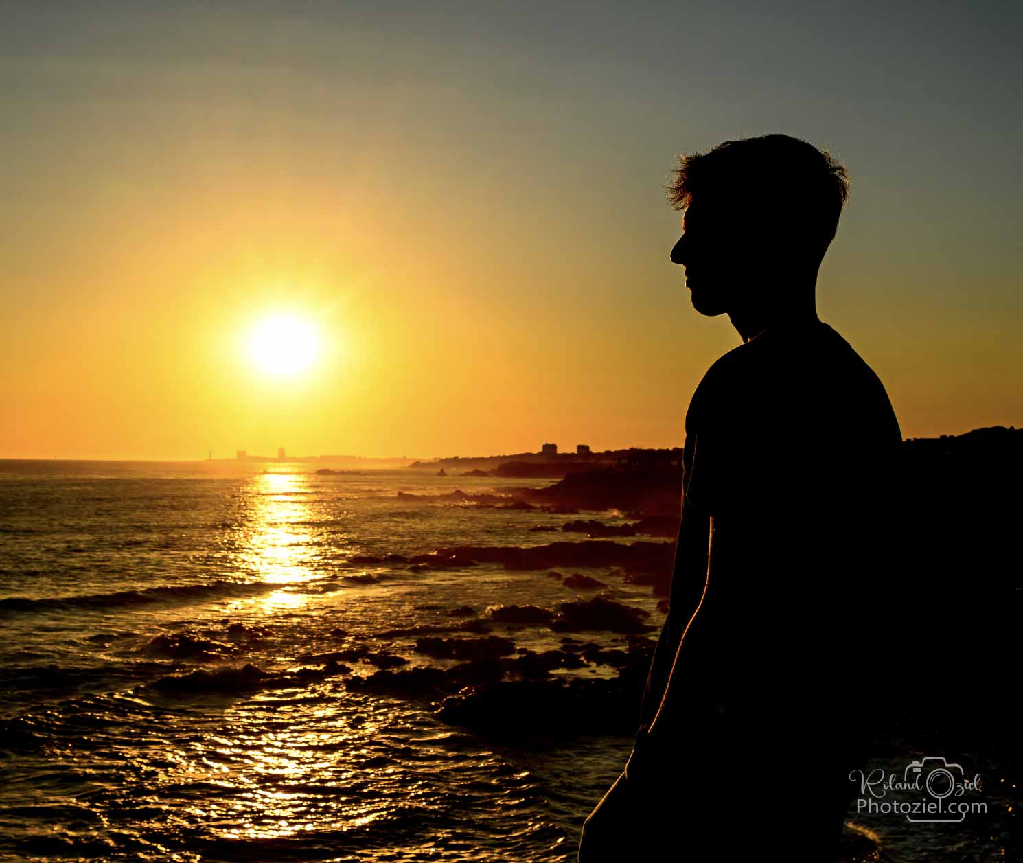 Photographie d&apos;un jeune homme au couher du soleil