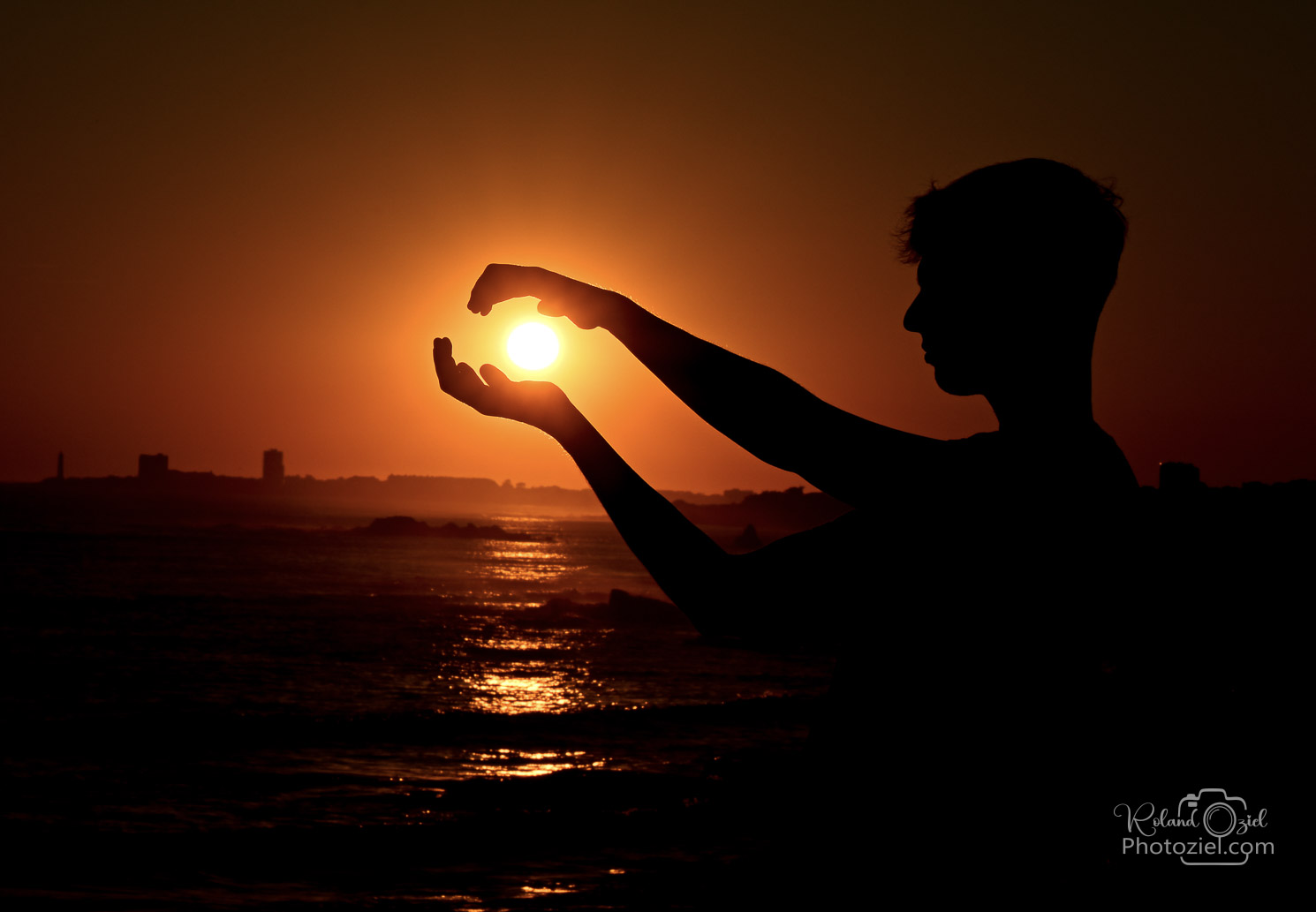 Photo avec l&apos;ombre d&apos;un jeune homme qui attrappe dans ses mains le soleil